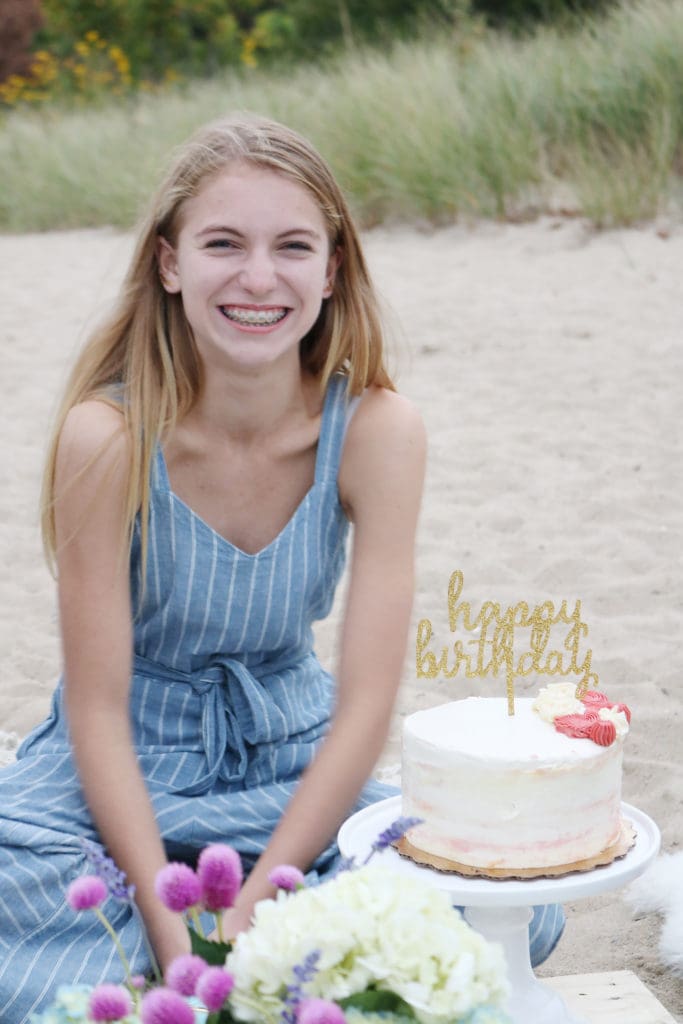 Boho Birthday Beach dinner with pillows and vintage rugs.  Set up plates and table decor on pallet and add pillows.  Birthday Beach dinner idea, beach dinner casual, lanterns and candles || Darling Darleen